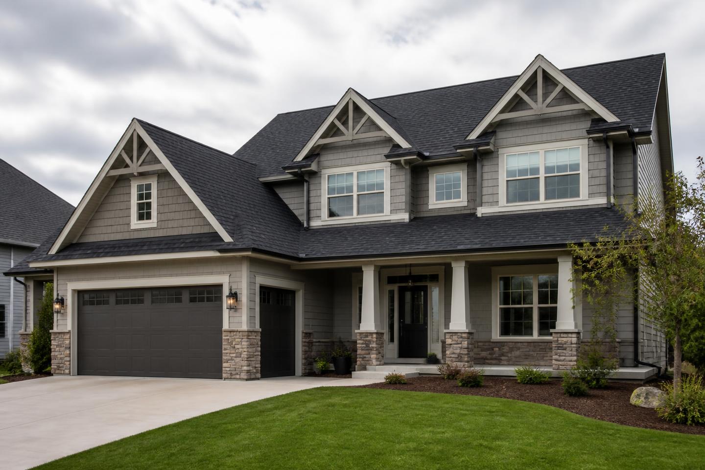 Suburban two-storey home with a dark grey architectural asphalt shingle roof and multiple gables